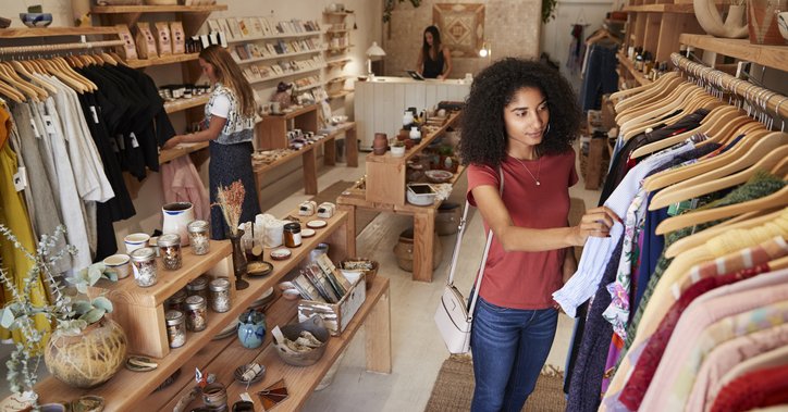 Two women browsing through clothes in a local shop.