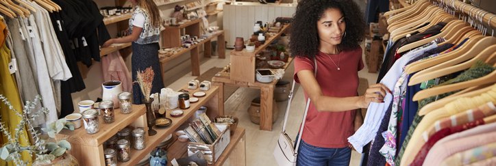 Two women browsing through clothes in a local shop.