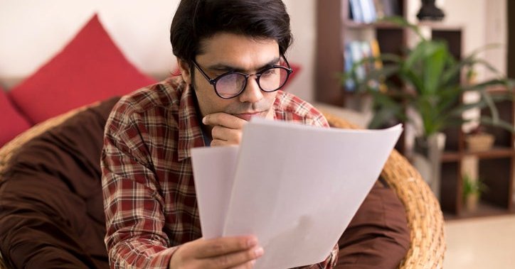 A man studies paperwork.
