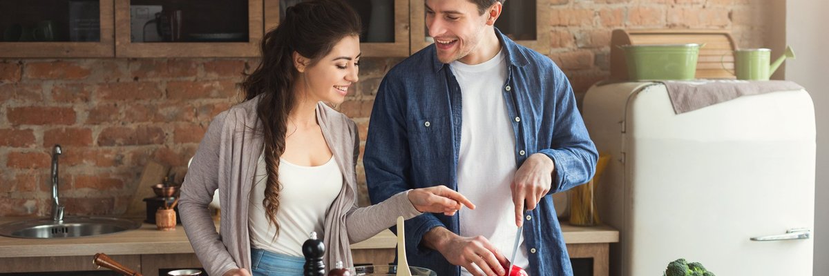 Smiling young couple cooking in kitchen