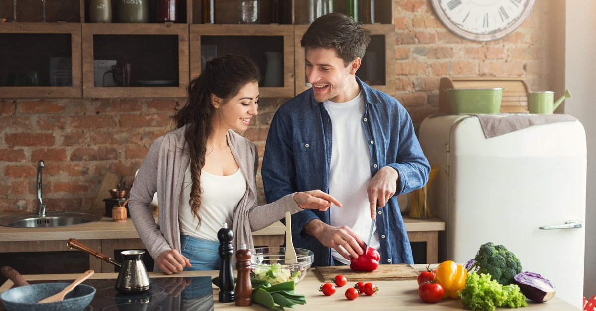 Smiling young couple cooking in kitchen