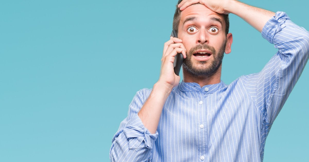 young man holding cellphone to his ear and holding his hand to his forehead like he made a mistake