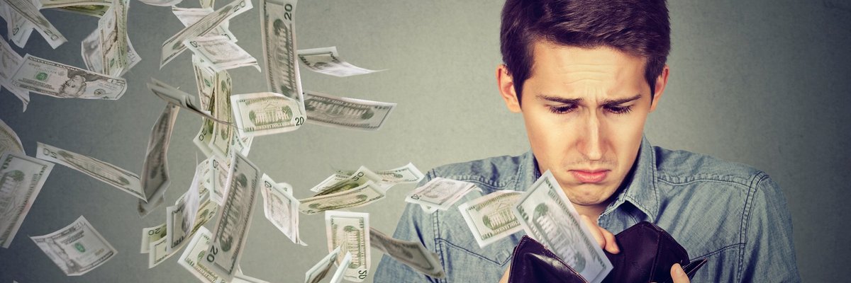 Young man with money flying out of his wallet