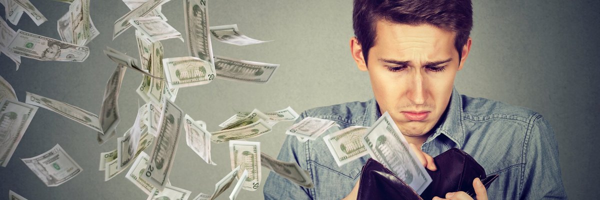 Young man with money flying out of his wallet