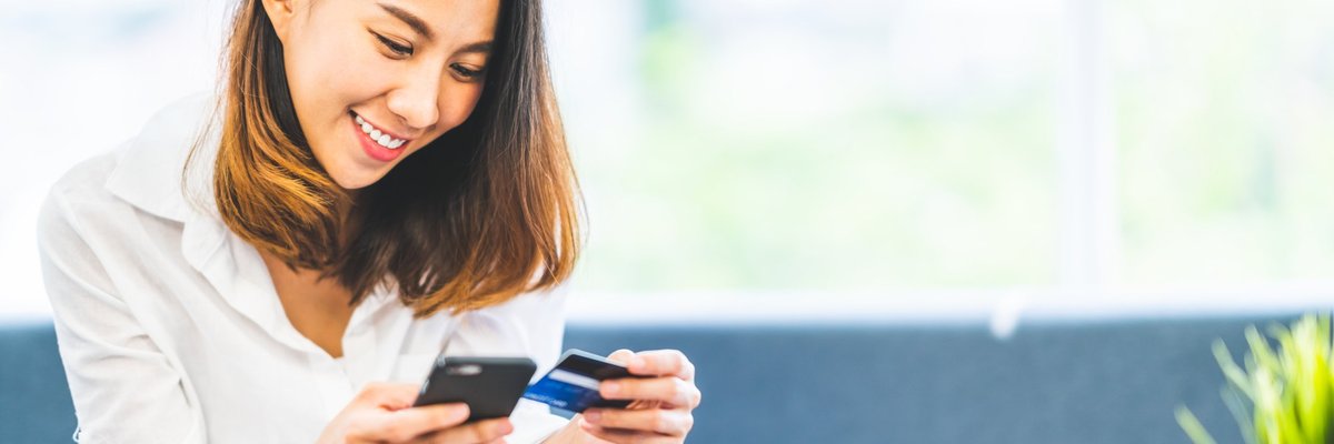Young woman holding phone and credit card