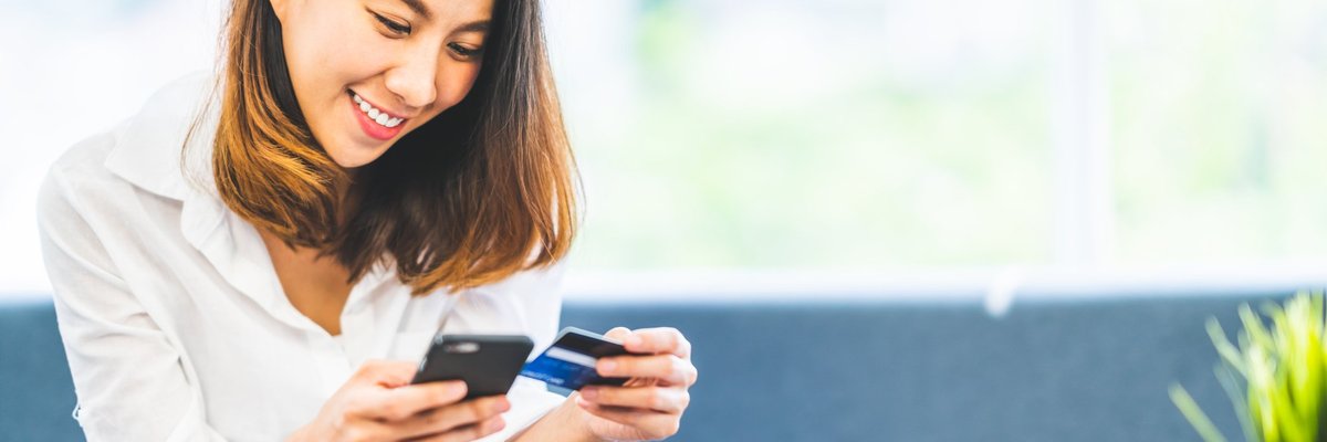 Young woman holding phone and credit card