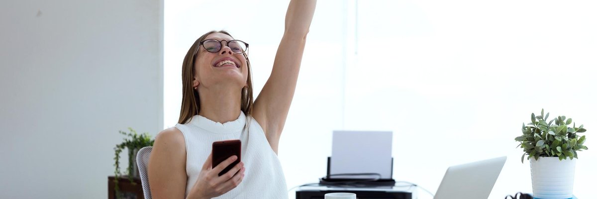 young woman pumps fist in office
