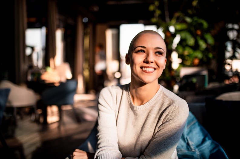 A happy young woman sitting in a sunny room.
