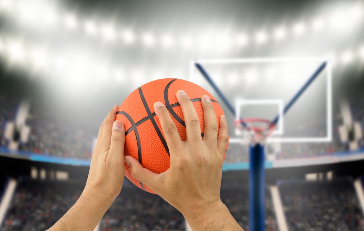 Man holding basketball in hands aiming for hoop.