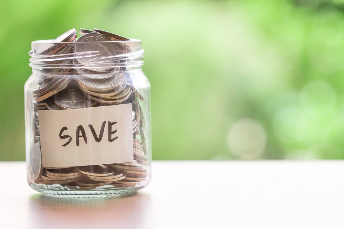 A jar full of coins with Save written on the side.