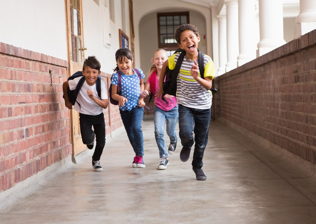 Cute students running in the school corridor.