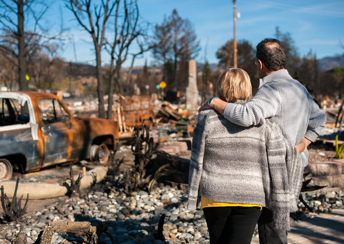 Couple checking ruins after fire disaster.