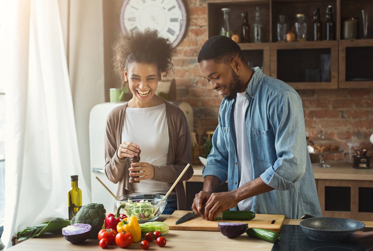 A happy young couple cooking at home.