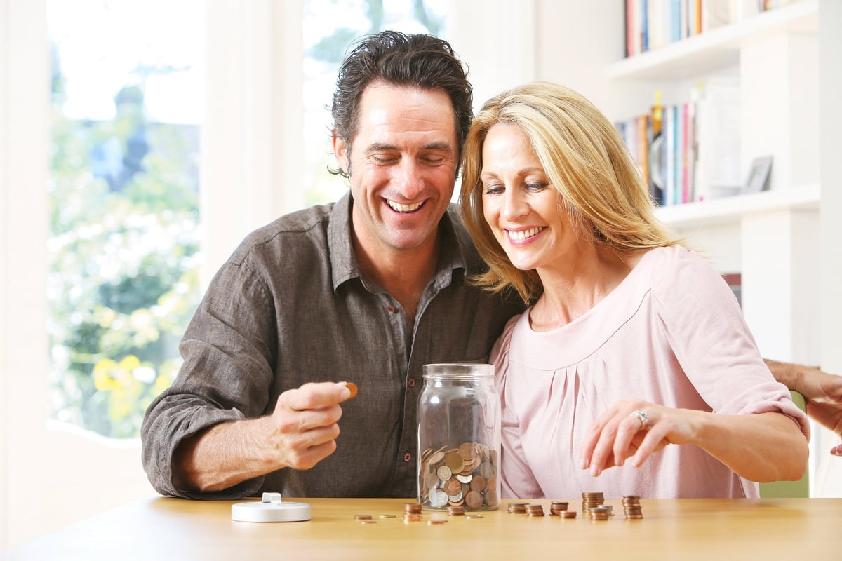 Couple counting change in jar.