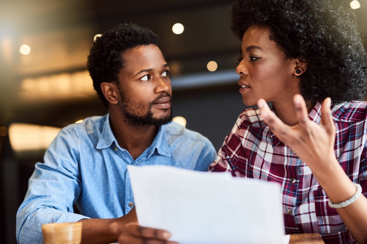 Couple dismayed by document in hands.