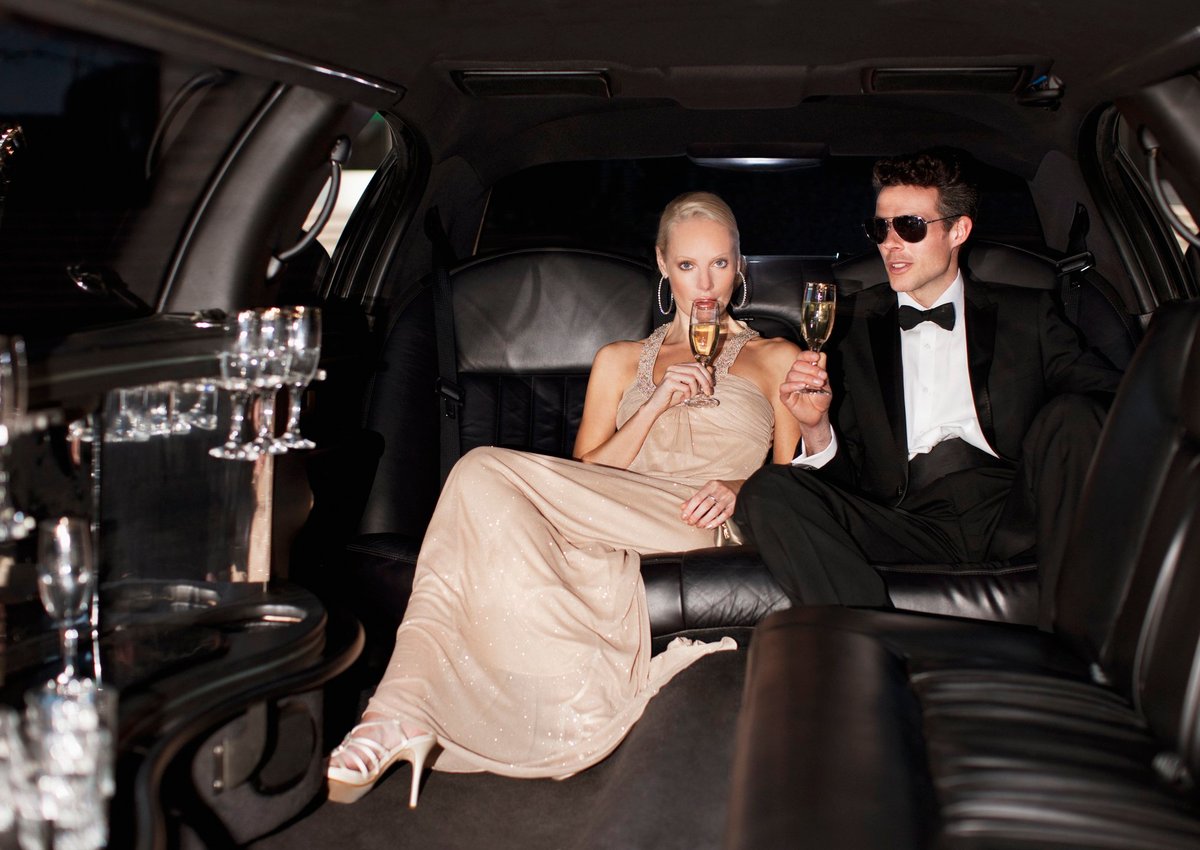 Couple drinking champagne in limo.