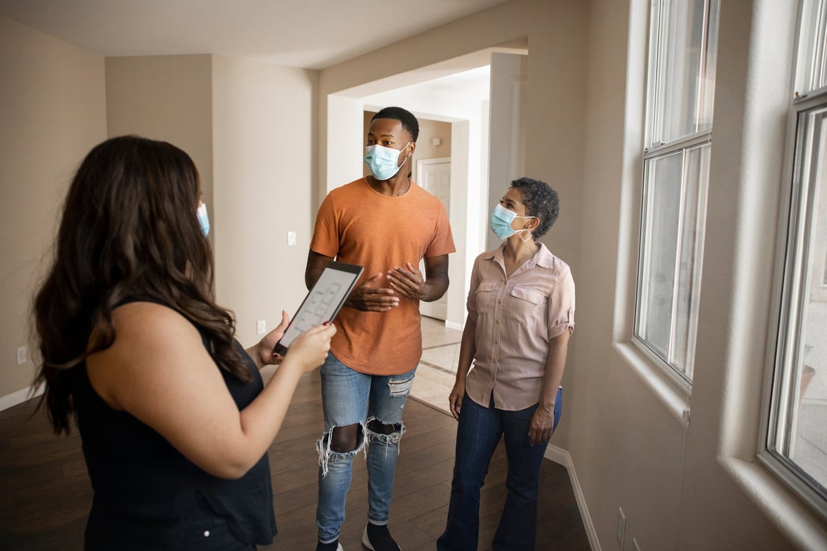 A couple look at a new house with their real estate agent.