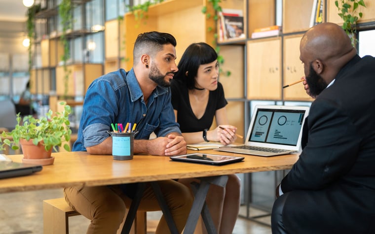 A couple meeting with a banker in an office.