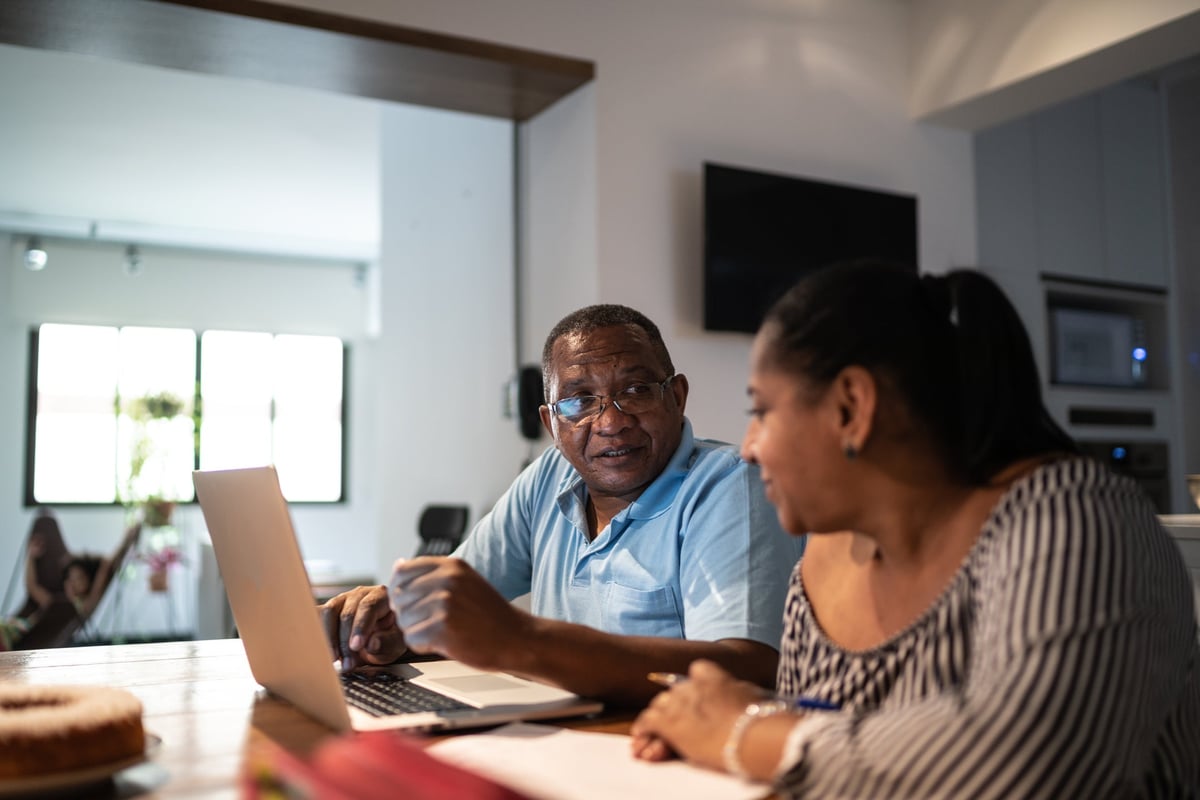 A couple sit at home and look over their personal finances.