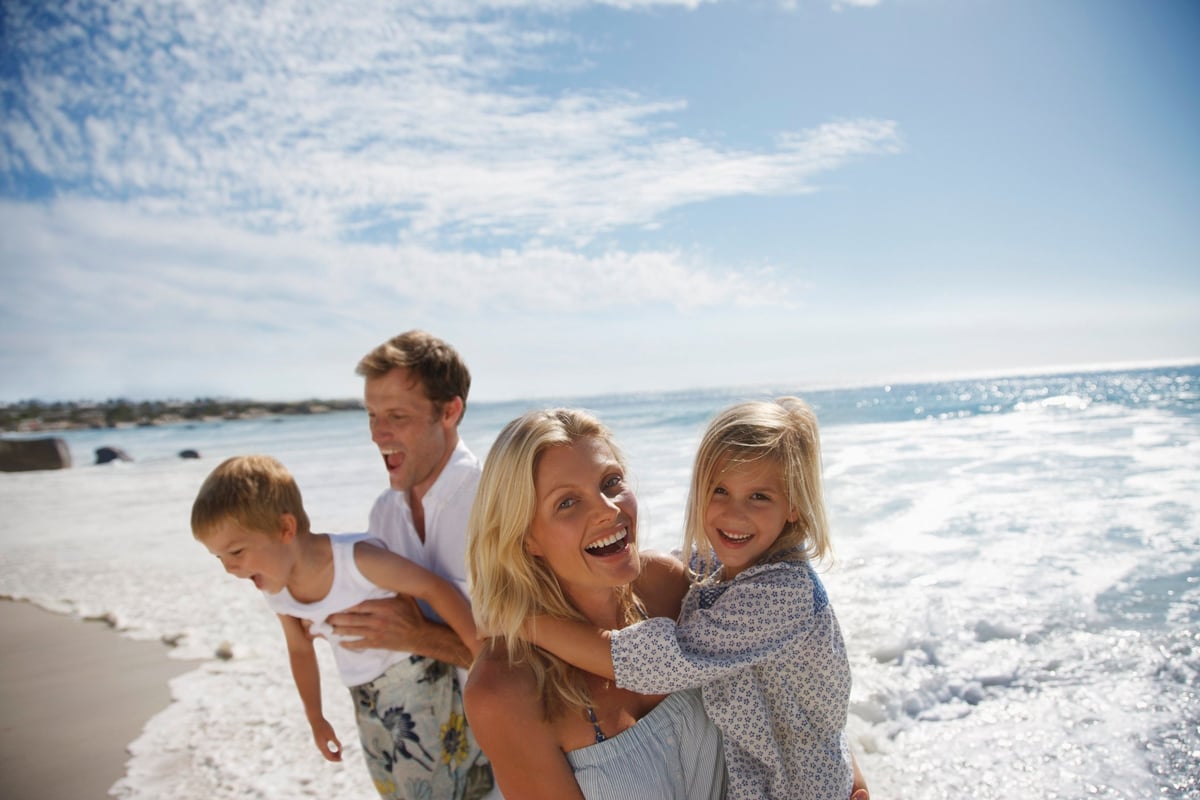 Man, woman, boy and little girl on the beach.