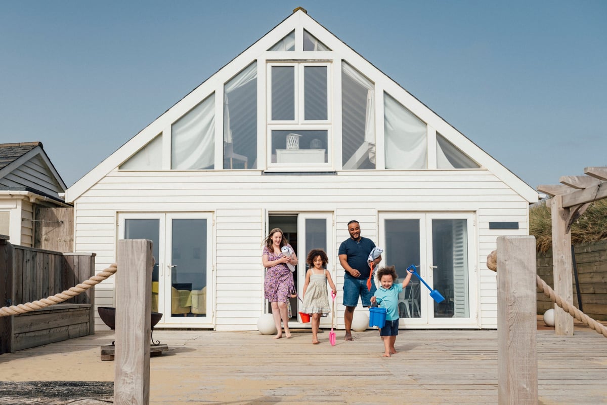 Family emerging from a beach house.