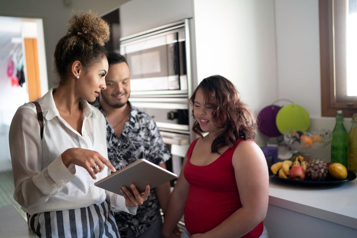 A couple looking at a pristine kitchen with a real estate agent.