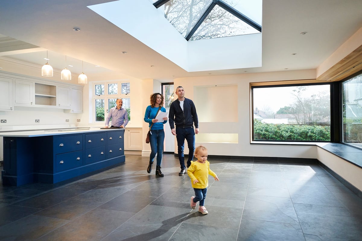 A family tours a large house with a realtor.