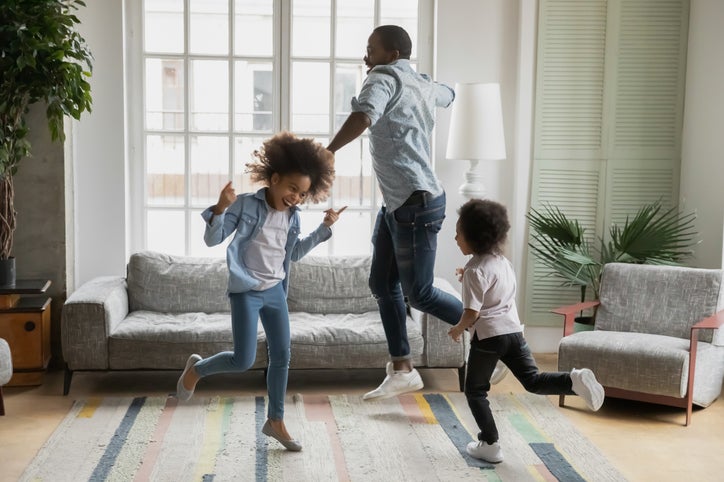Man and kids dance around new home.