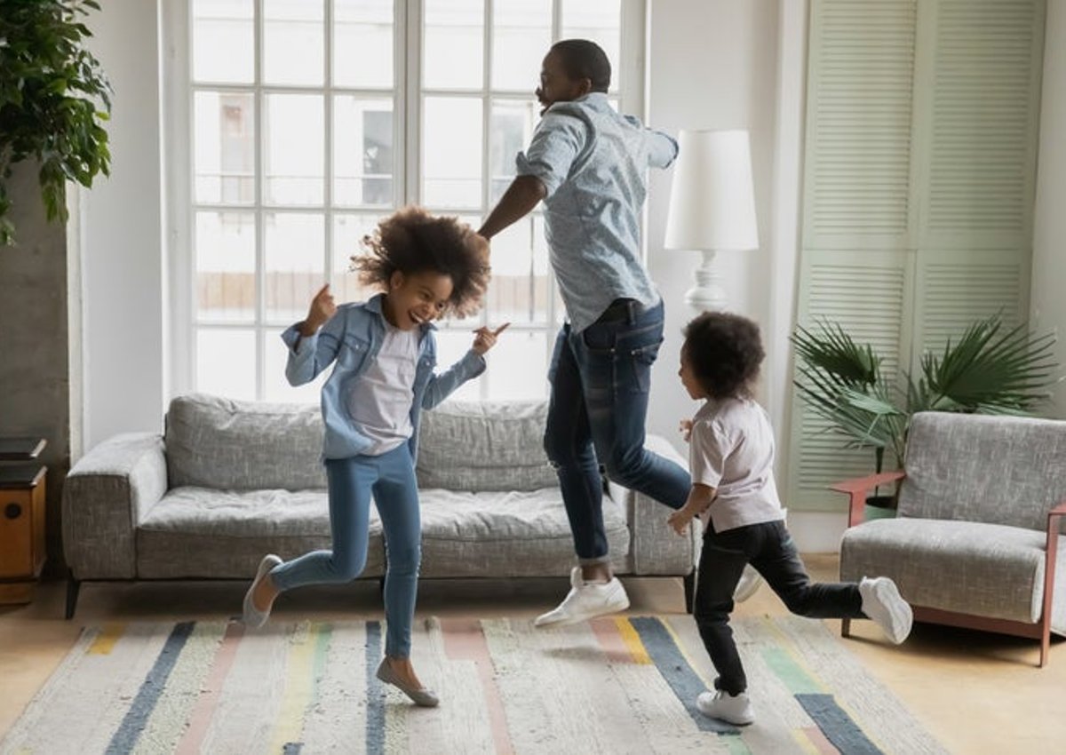 Man and kids dance around new home.