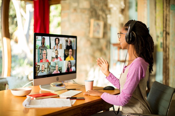 A woman smiles during a video conference at home for work.