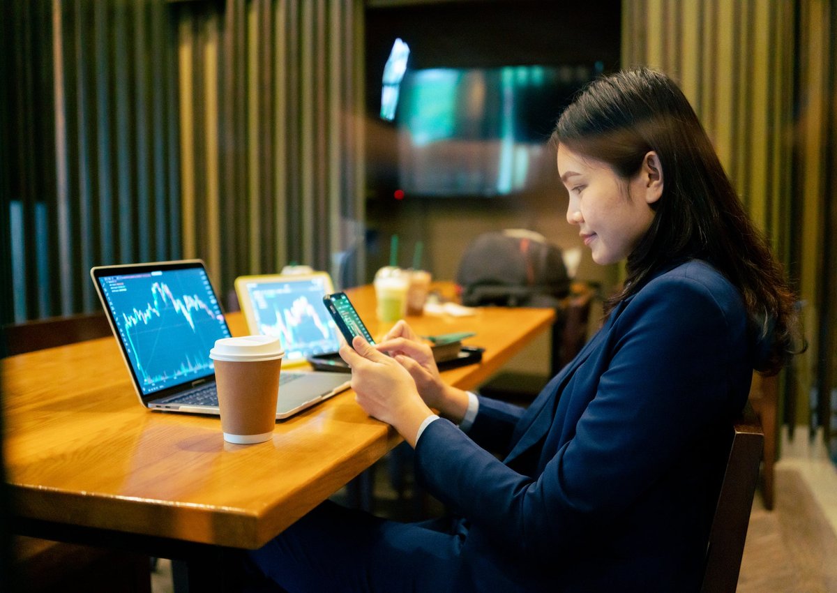 A business worker looks at crypto or stock graphs on their laptop.
