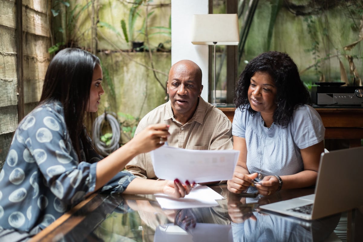 A couple meets with a financial advisor in their home.