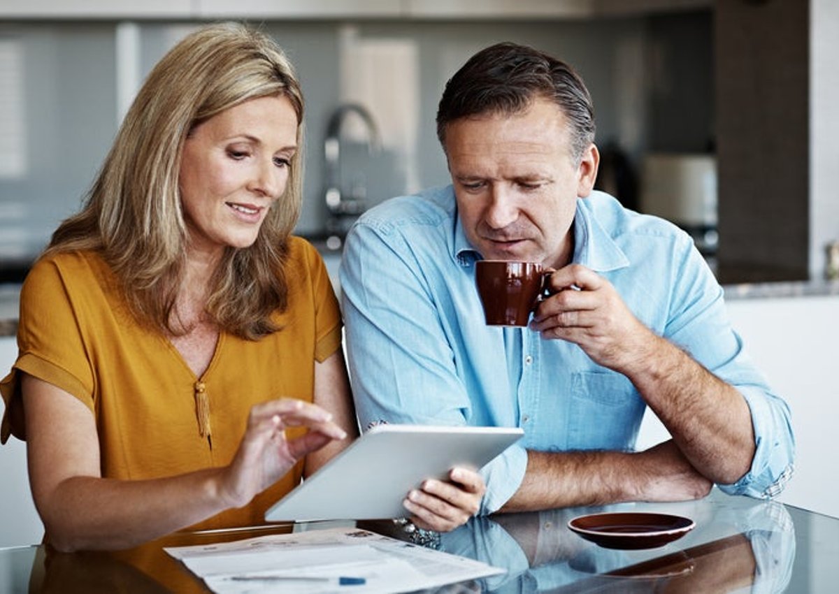 A mature couple goes over financial paperwork at home.