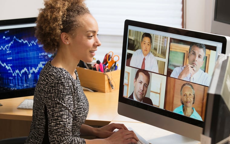 Business worker teleconferences their coworkers from a home office.