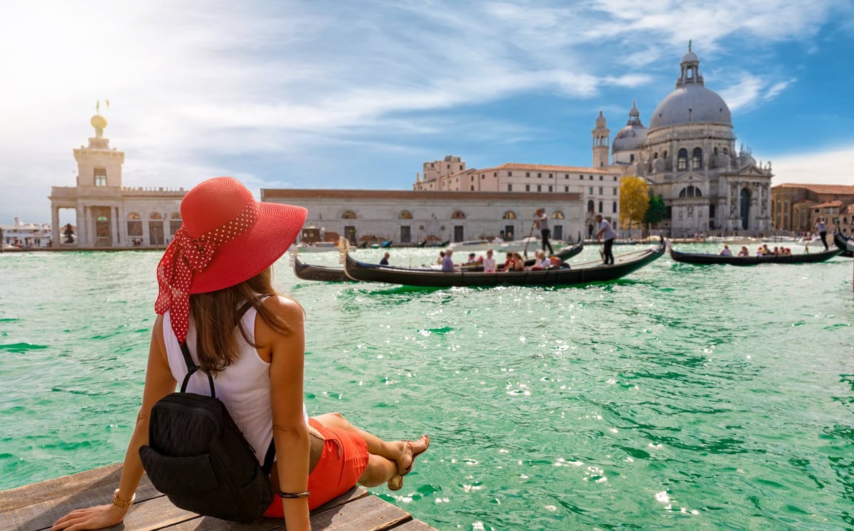 Women sitting along a river in Italy