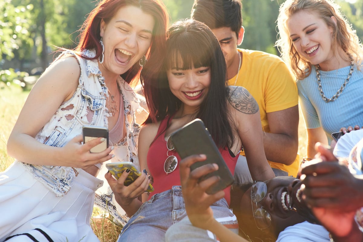 Group of friends hanging out and using their cell phones.