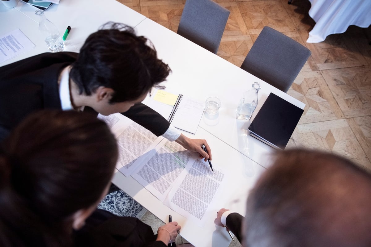 Group of professionals closely reviewing documents.