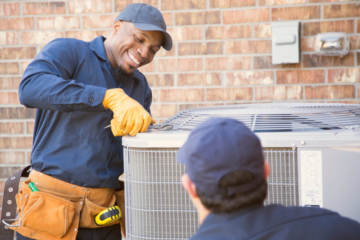HVAC technicians servicing an outdoor unit.