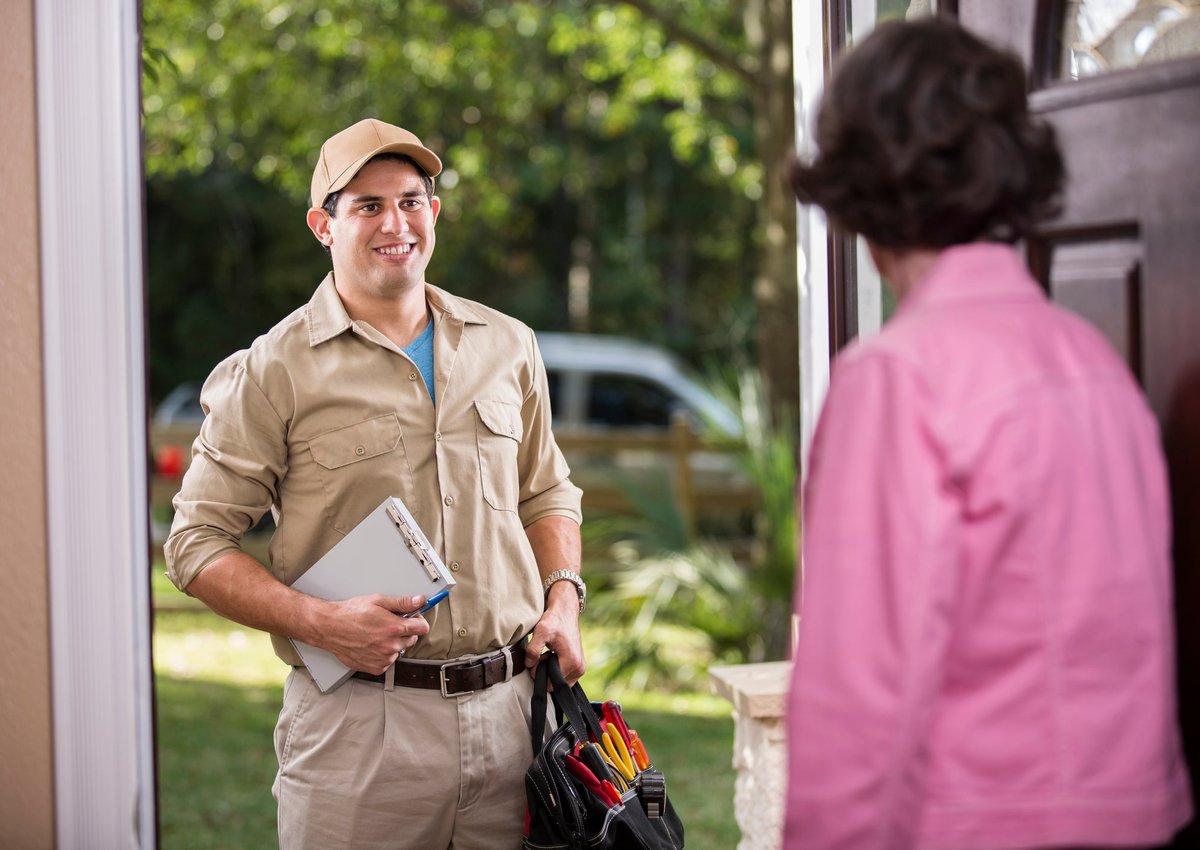 Homeowner opening the door for repairman.