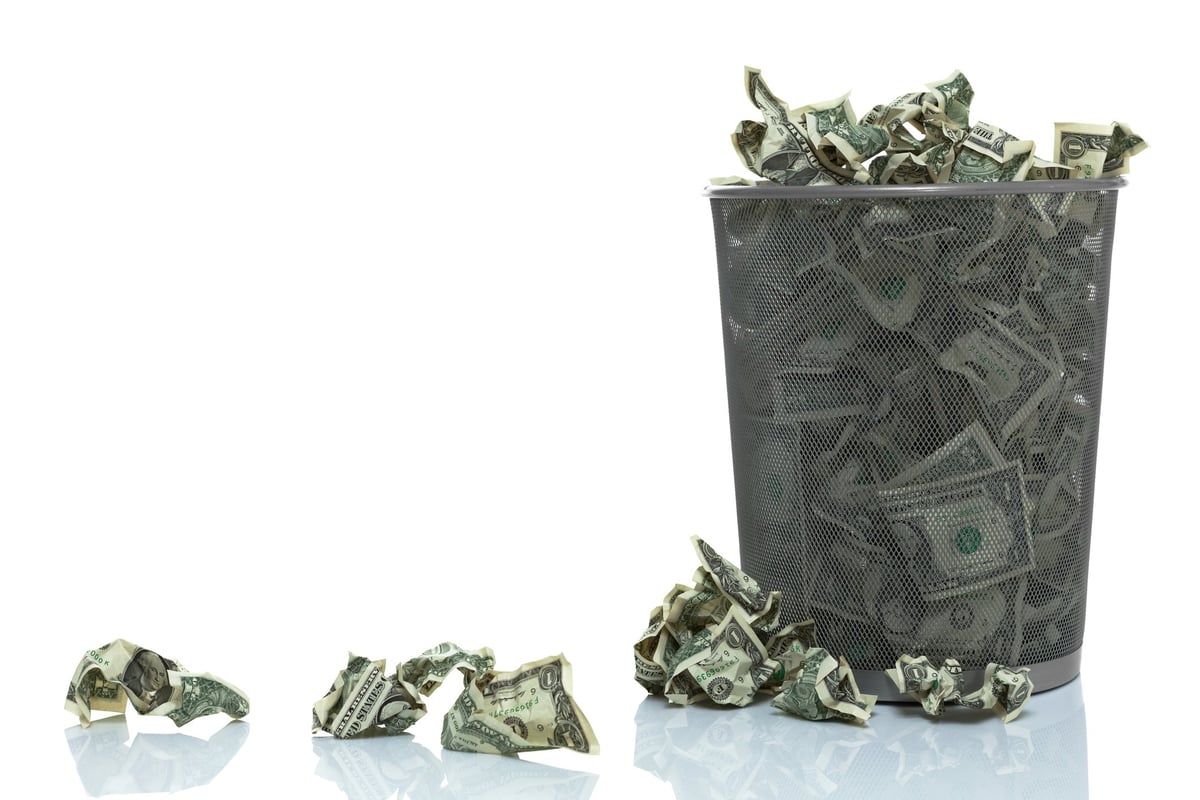 Trash can full of dollar bills.