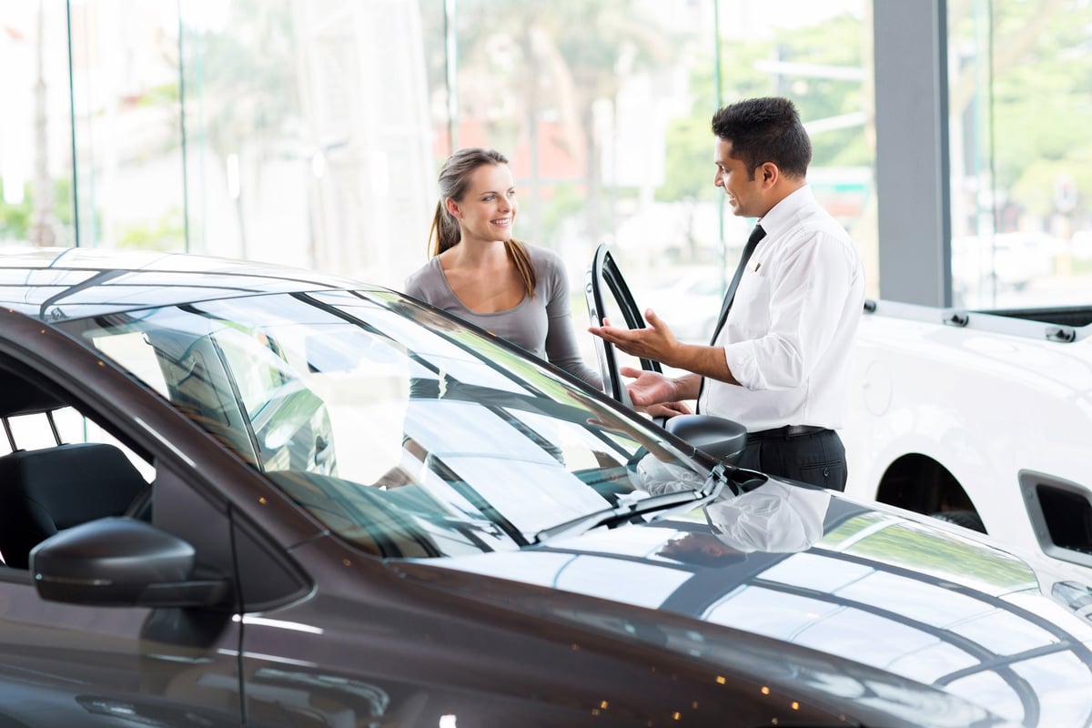 Dealer showing car to female customer