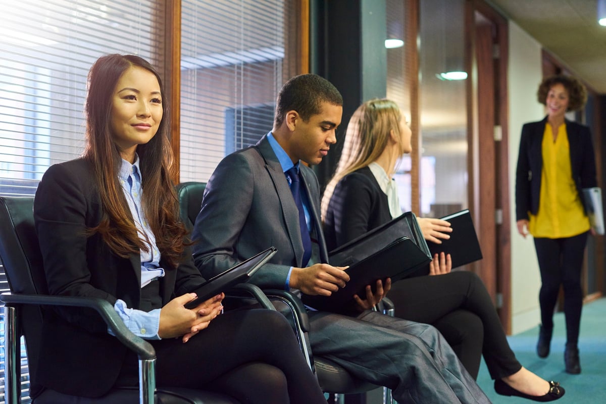 Three people are sitting in an office, waiting to be interviewed.