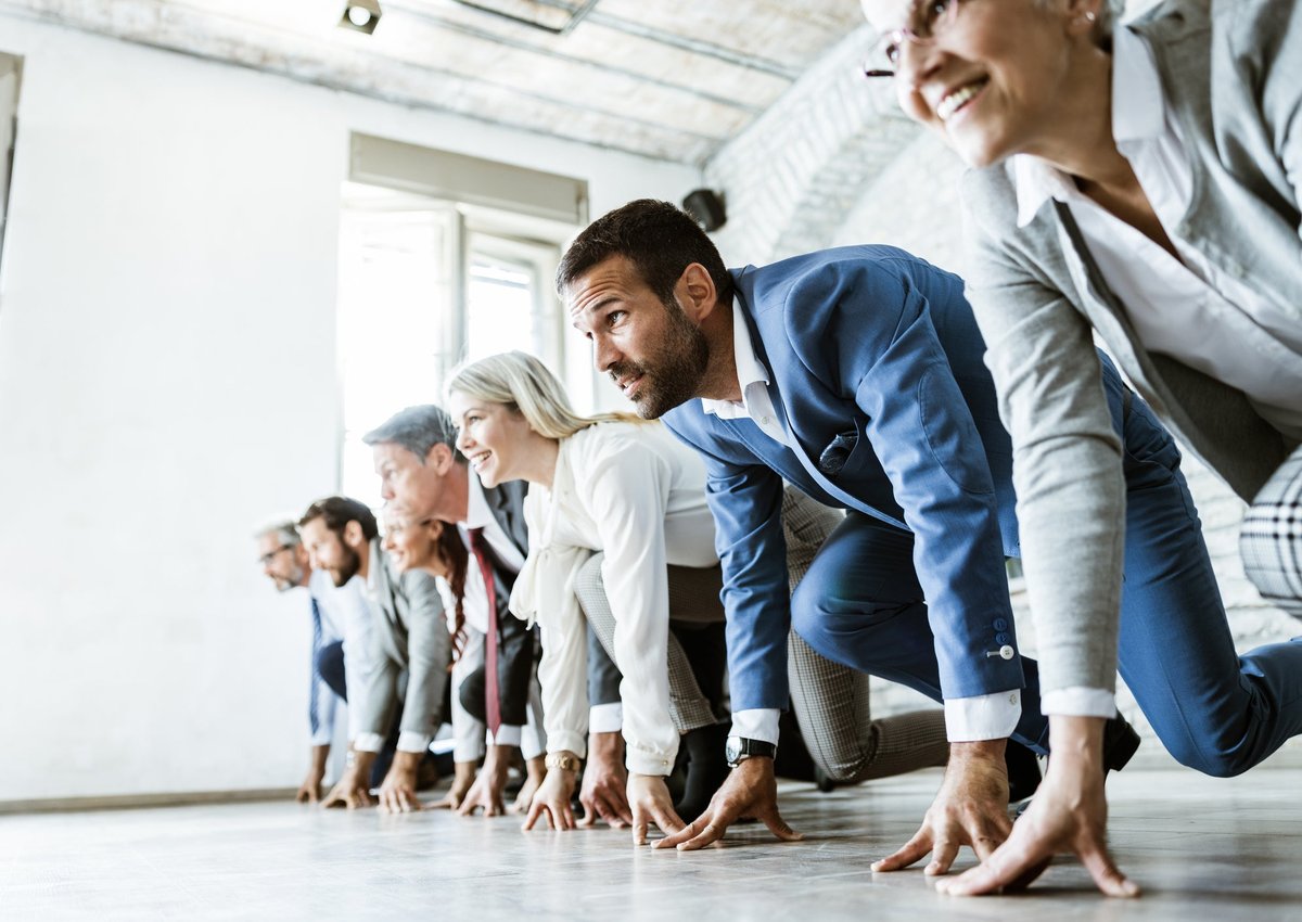 People in business attire line up for a race.
