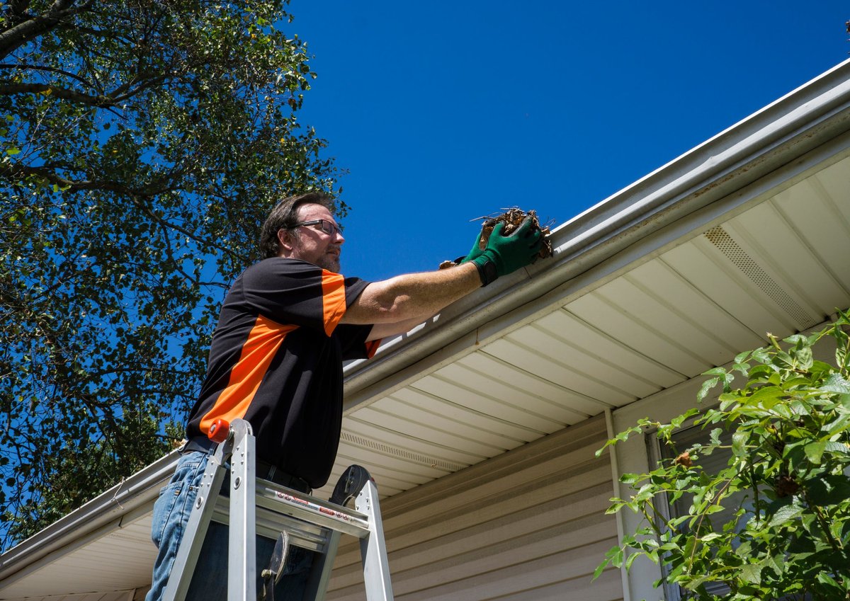 Man cleaning home's gutters.