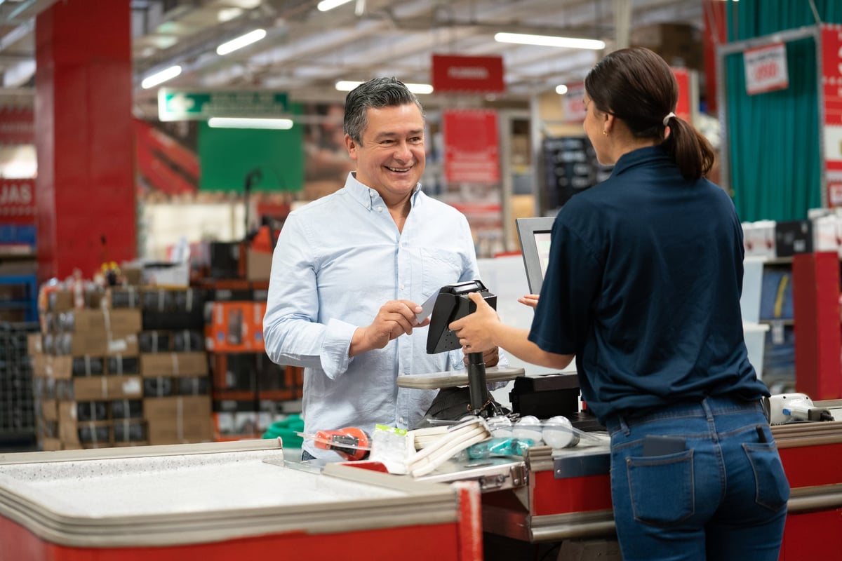 A man uses his credit card to pay for purchases at a home improvement store.
