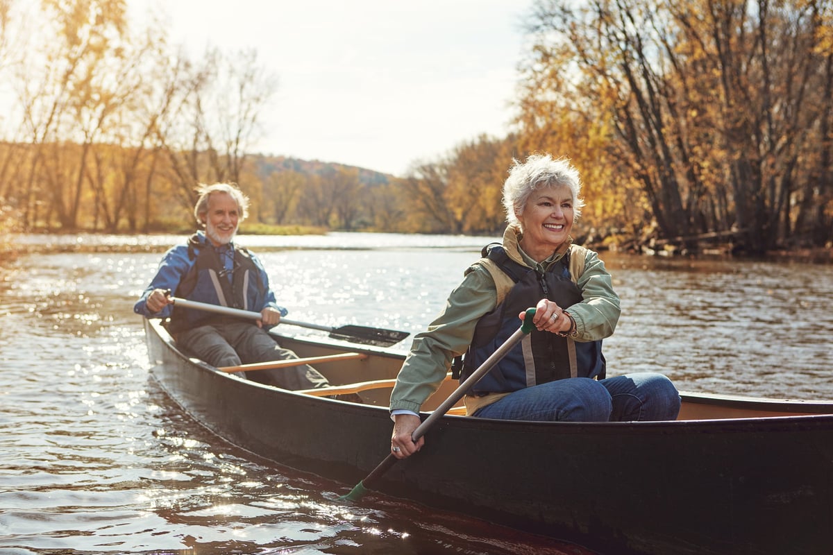 Mature couple rowing together in a canoe.