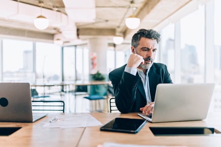 Mature man looking at his laptop with conce on his face.