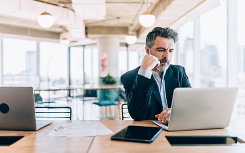 Mature man looking at his laptop with conce on his face.