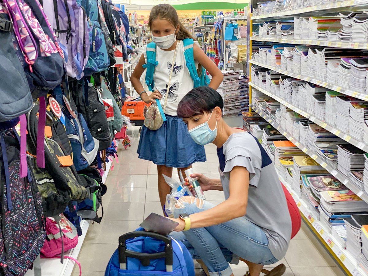 Mother and daughter shopping for backpacks and other school supplies.