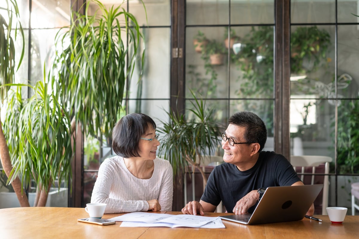 An older couple sit together and go over their investment portfolio.